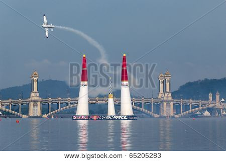 PUTRAJAYA, MALAYSIA - MAY 17, 2014: Matthias Dolderer from Germany in an Edge 540 V3 plane flies through the race course over Putrajaya lake at the Red Bull Air Race World Championship 2014.