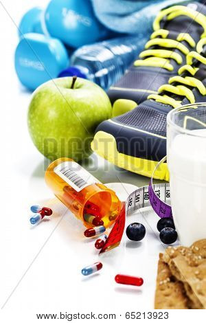Different tools for sport and pills (Vitamins or Fitness Supplement) on white background - sport, health and diet concept