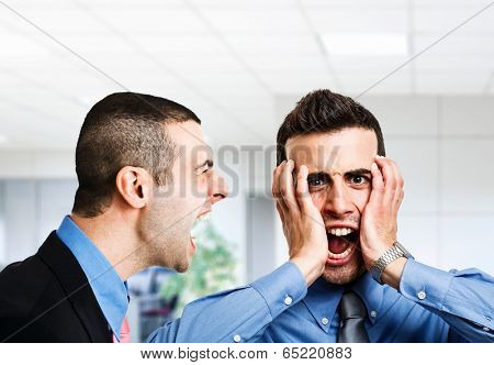 Angry businessman shouting to an employee