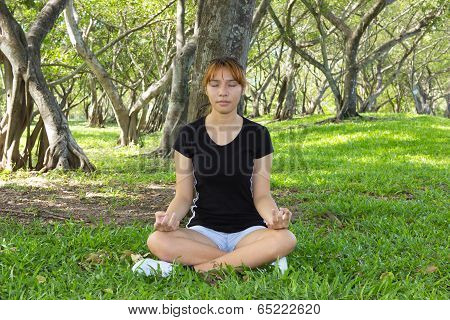 Young Women Sitting With Hunker And Close The Eyes At The Park