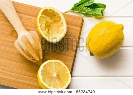 squeezed lemon fruit and citrus reamer on kitchen table