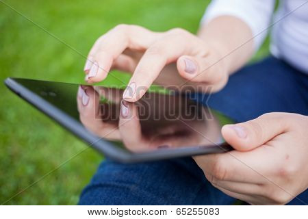 Woman using digital tablet PC in the park