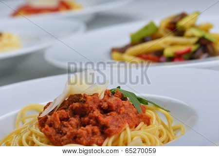 Italian spaghetti topped with bolognaise, or bolognese, sauce with tomatoes, meat and cheese on a plain white plate