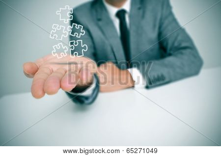 a businessman with some jigsaw puzzle pieces in his hand