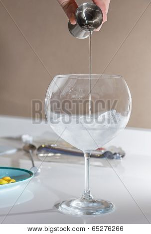 Barman pouring drink to prepare gin tonic cocktail