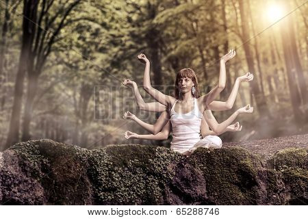 Eight arm woman sitting on a forest and pray