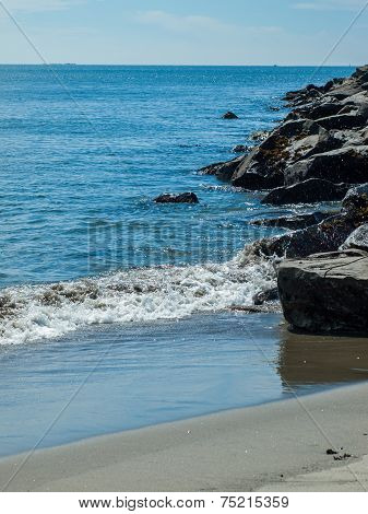 Gentle Beach Waves With A Rock Jetty