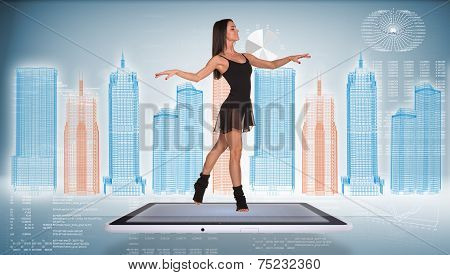 Beautiful woman dancer dancing on screen of tablet pc. Wire-frame business city and graphs