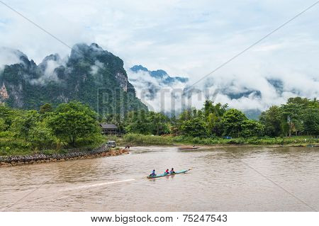 VANG VIENG LAO P.D.R. - October 24 : Unidentified tourists are rowing kayak boats in Song River on O