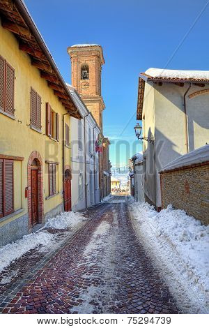 Narrow cobblestone street among house in town of Montelupo Albese in Piedmont, Italy (vertical composition).