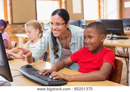 Cute pupils in computer class with teacher at the elementary school