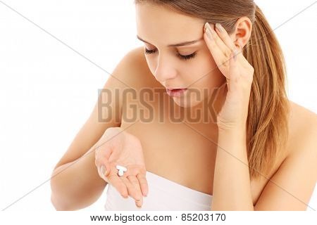 A picture of a woman with headache holding pain killers over white background