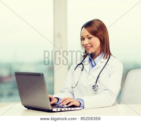 medicine and healthcare concept - busy doctor with laptop computer