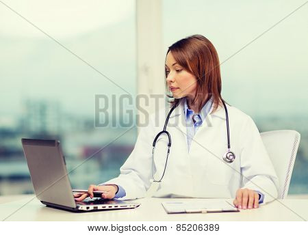 medicine and healthcare concept - busy doctor with laptop computer
