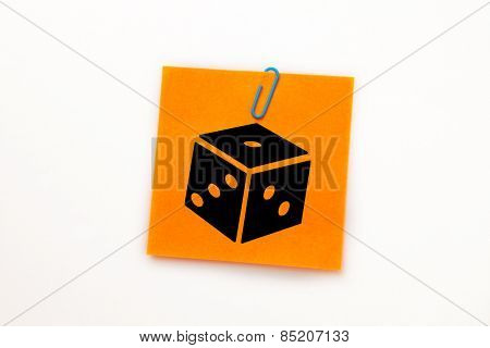 Dice against orange adhesive note with a paperclip