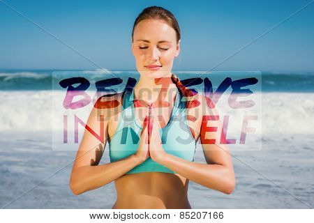 Fit woman meditating on the beach against believe in myself