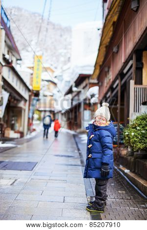Little girl at old district of hot spring resort town Shibu onsen in Japan on winter day