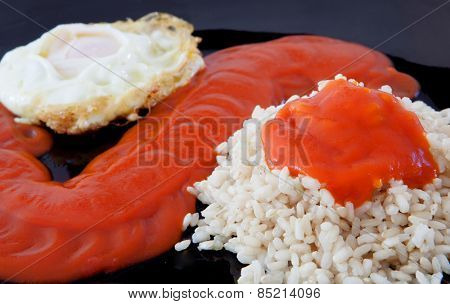 Fried egg with rice overcooked and tomato sauce