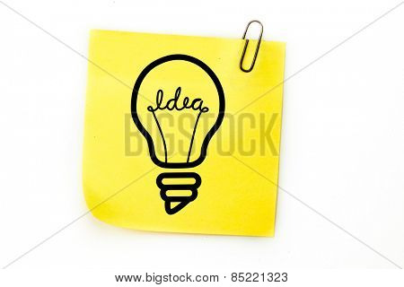 Light bulb against sticky note with grey paperclip
