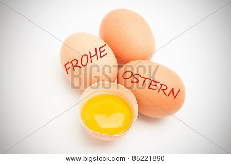 frohe ostern against three eggs with a yolk in half a shell