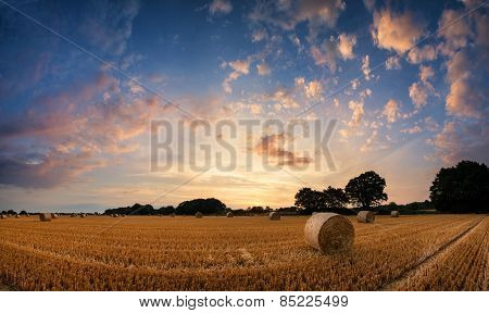 Stunning Summer Sunset Landscape Over Feild Of Hay Bales