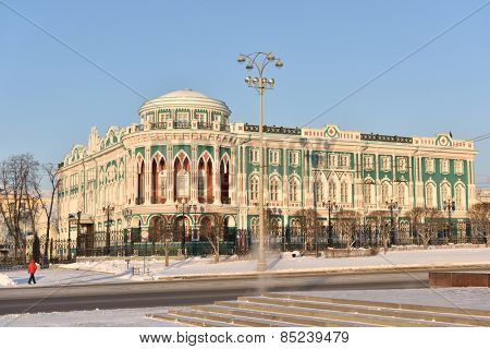 YEKATERINBURG, RUSSIA - JANUARY 2, 2015: Man near the House of N. I. Sevastianov in a winter day. Built in the first quarter of XIX century, now it is one of the most notable landmark of the city