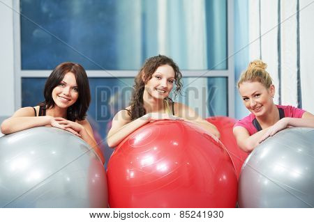 group of young smiling woman with finess ball in gym