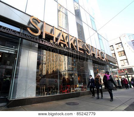 NEW YORK CITY - FEB. 25, 2015:  Pedestrians walk past a Shake Shack restaurant. Shake Shack is a fast casual restaurant chain based in New York City

