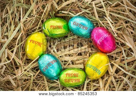 frohe ostern against easter eggs in a circle on straw