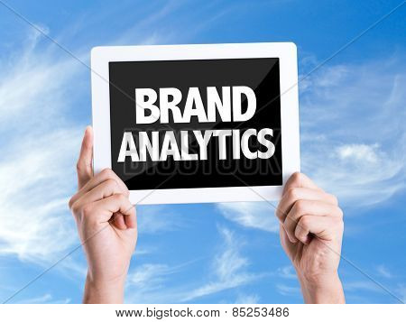 Tablet pc with text Brand Analytics with sky background