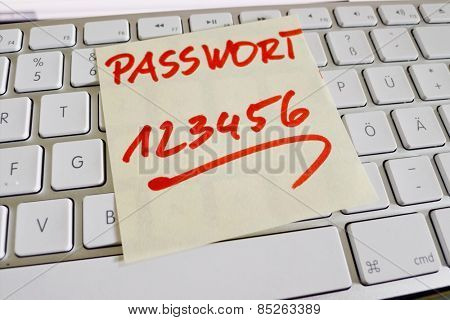 a memo is on the keyboard of a computer as a reminder password 123456