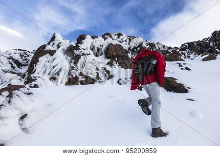 Climber Walking Through Snow, Ice And Rocks.