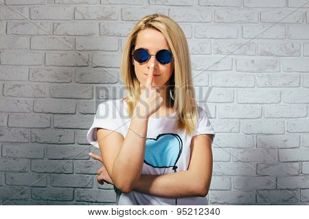 Beautiful blonde girl in branded sunglasses smiling