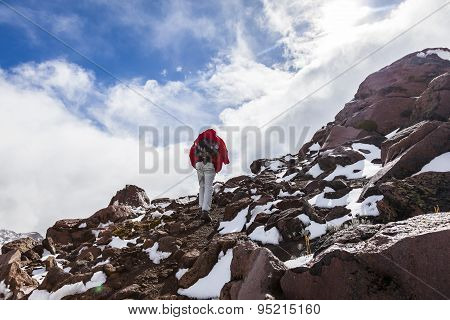 Climber Walking Through Snow, Ice And Rocks.