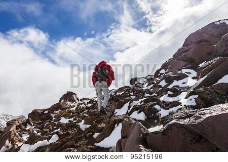 Climber Walking Through Snow, Ice And Rocks.