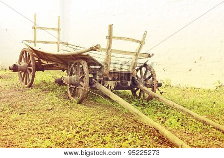 Vintage Old Rough Wooden Cart In Front Of Old Clay Wall.