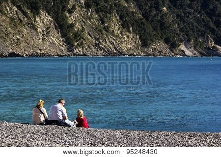 Family Resting On The Beach In Camogli, Italy