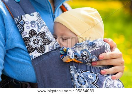Newborn Baby And Mother Outdoors Walking With Sling.