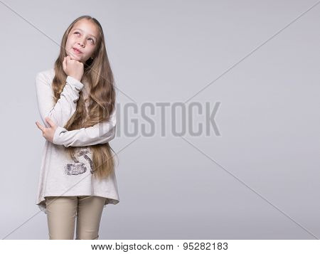 portrait of bewildered teenage girl standing on a gray background