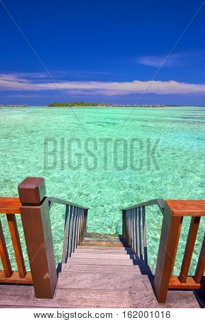 Stairs leading to tropical lagoon on Maldives island.