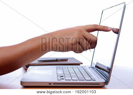hand and finger touch screen on monitor a laptop on a wooden table