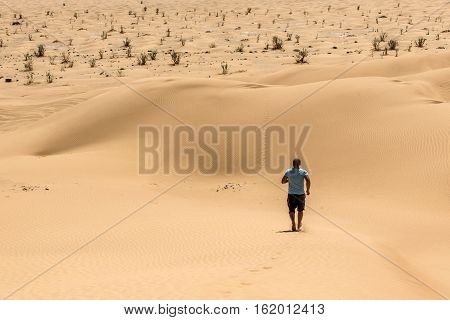 Man tourist in desert rub al khali in Oman running in sand