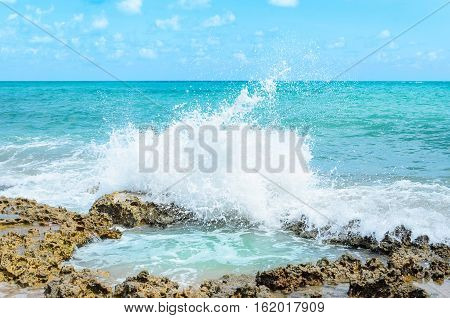 Ocean Water Splashing On Rocks And Forming A Natural Pool In The Center Of The Image. Sunny Day, Ver