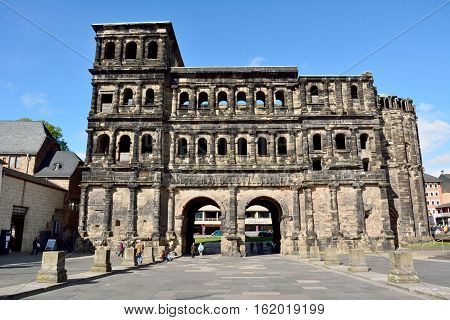 Trier, Germany - April 26, 2016. 2nd-century Roman city gate Porta Nigra in Trier, with surrounding buildings and people.
