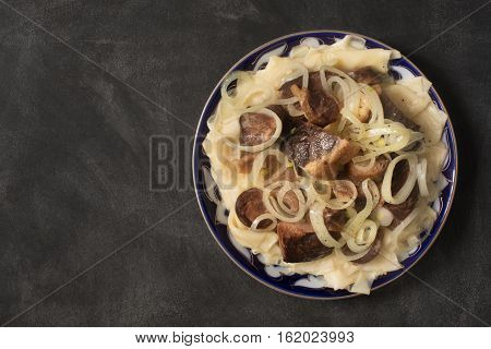 National Kazakh dish - Beshbarmak prepared with meat and pasta on the dark chalkboard
