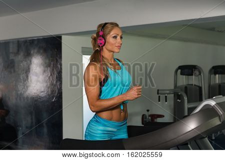 Healthy Mature Woman Running On Treadmill