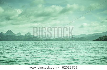 Silhouette at sunrise Mountain silhouette view with sky cloud fog and water surface at ratchaprapa dam Suratthani Thailand.