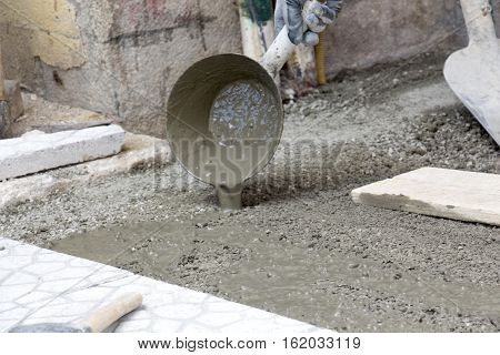 picture of a Worker pouring cement for pavement installation
