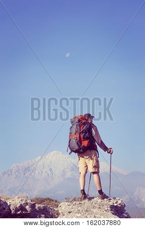 Summer hiking in the mountains with a backpack .