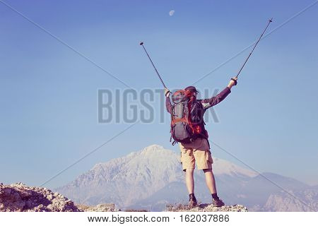 Summer hiking in the mountains with a backpack .